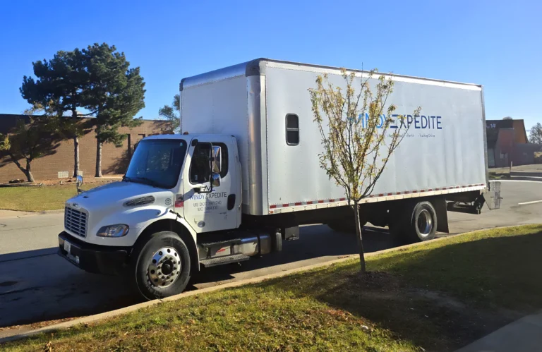 Windy Expedite Freightliner box truck parked outside distribution center