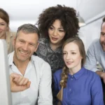 Team members smiling while reviewing logistics operations on screen