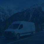 Construction equipment performing road stabilization and paving on a remote stretch of the Alaska Highway.