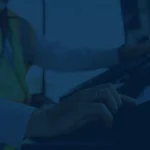 A professional truck driver using an Electronic Logging Device (ELD) to verify compliance data.