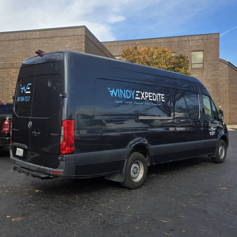 Windy Expedite branded cargo van parked outside a commercial facility, ready for time-critical freight delivery