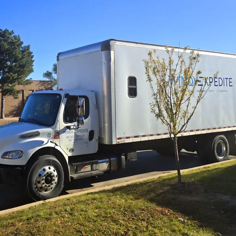 Windy Expedite Freightliner box truck parked outside distribution center